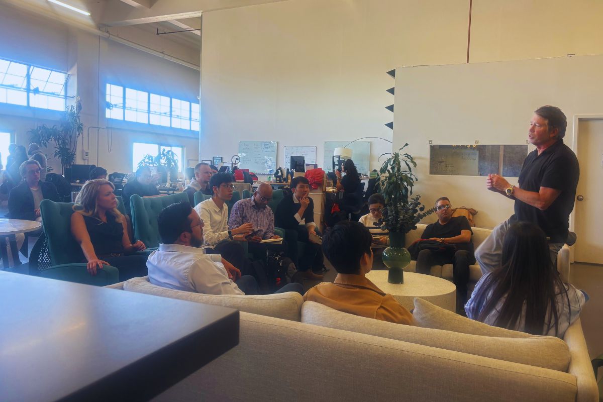 SOSV host standing and addressing a seated audience of founders and investors in the SOSV San Francisco lounge during Frontiers Day