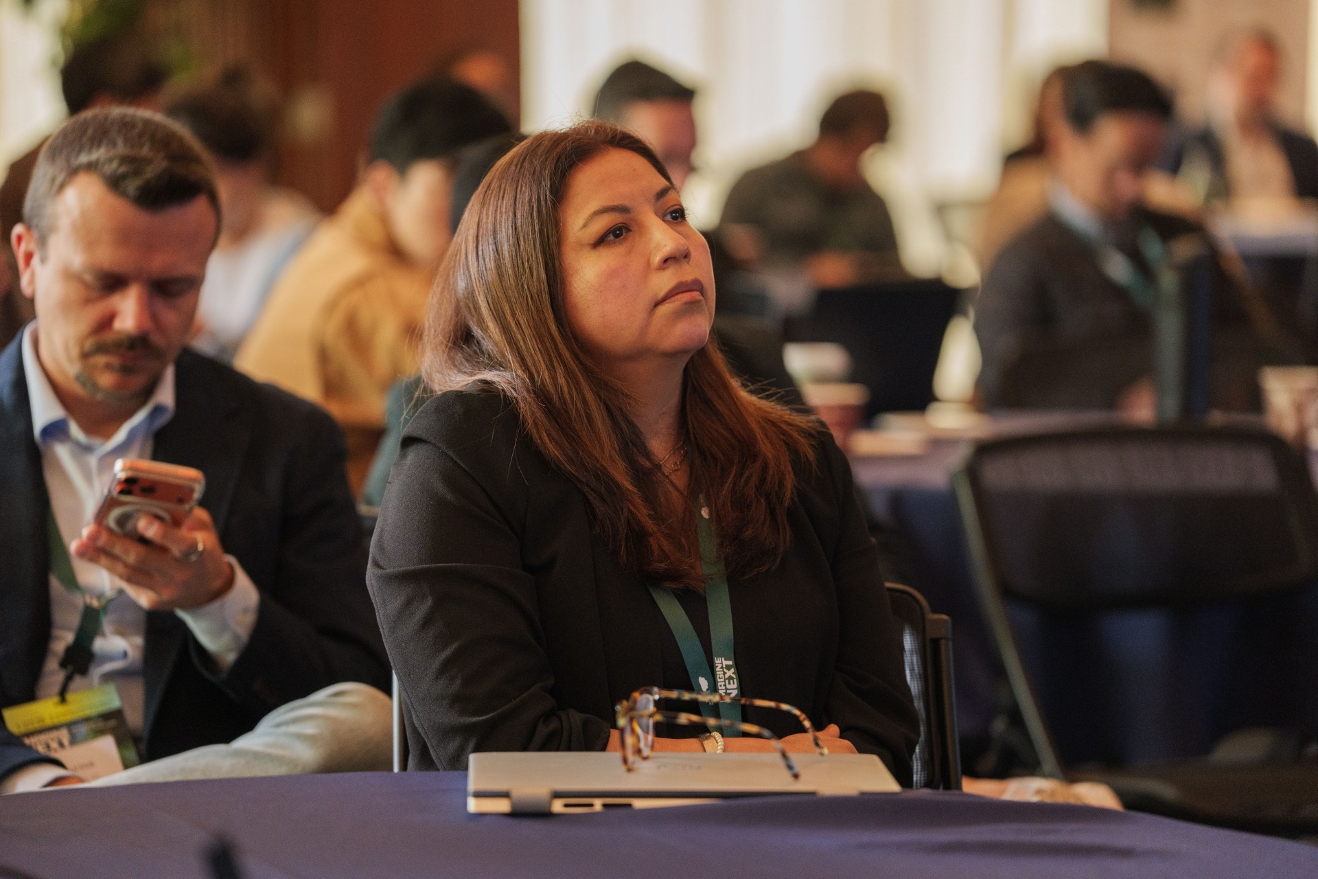 Delegate listening attentively in the audience during a pitch
