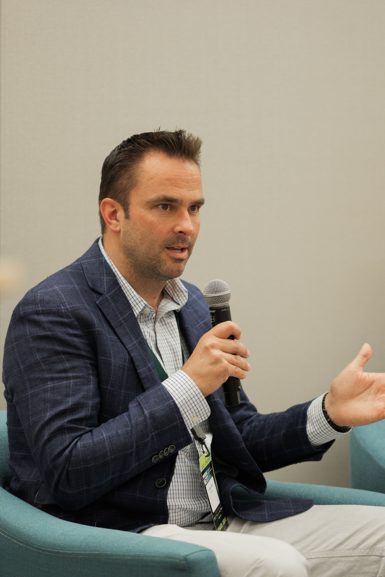 Portrait of Dr. Ryan Gilliam, CEO of Fortera, gesturing with mic while speaking on the Capital Day fireside chat 'Crossing the Deployment Valley — Founder Perspective'