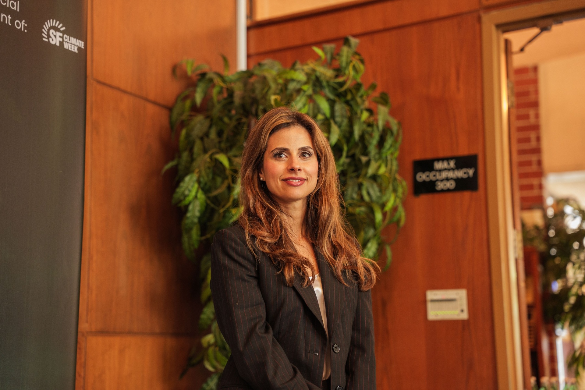 Keynote speaker Mariam portrait beside the SF Climate Week banner
