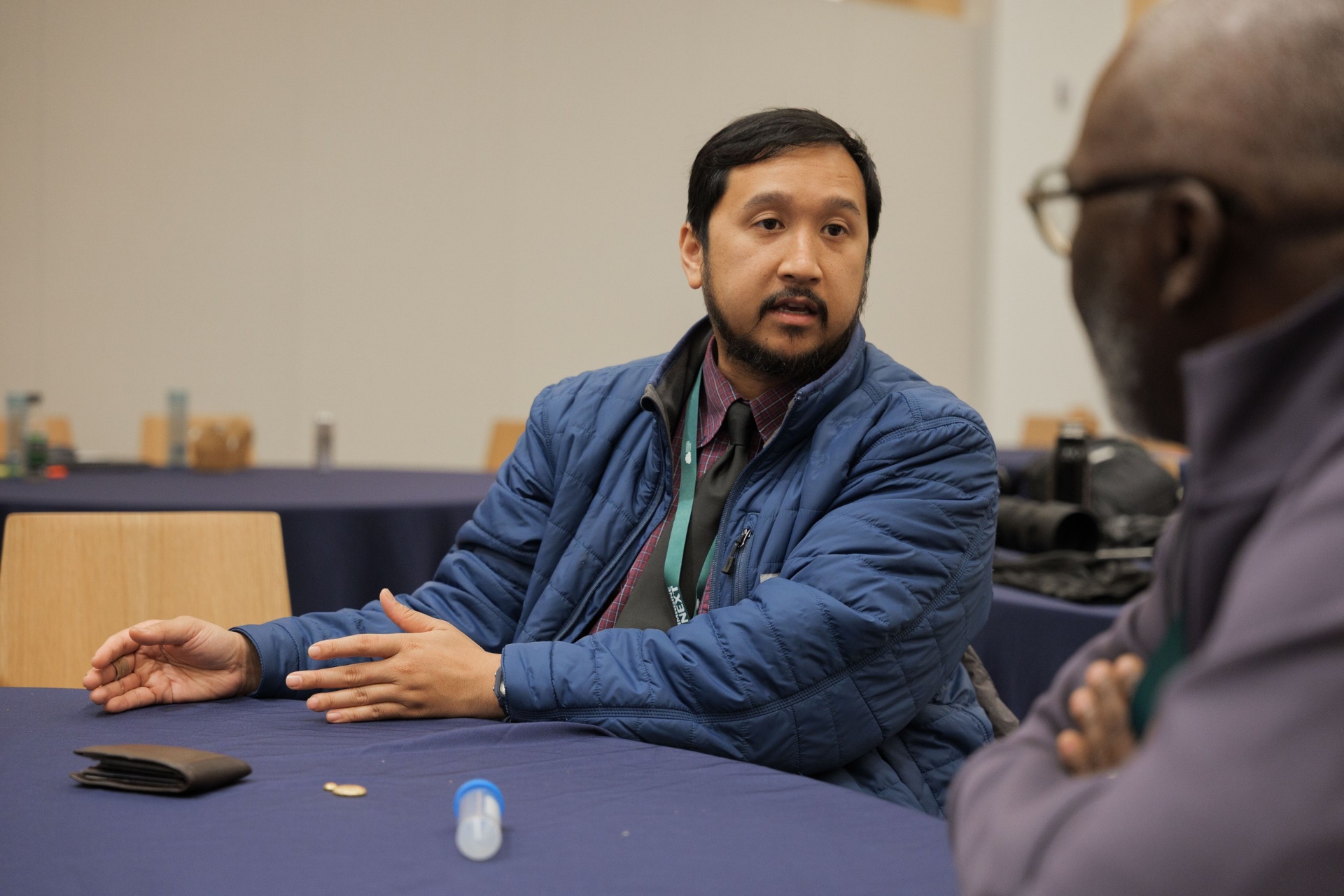 Founder in a blue jacket speaking with hands gesturing during the Capital Day Curated Capital Matchmaking Sessions at UC Law SF