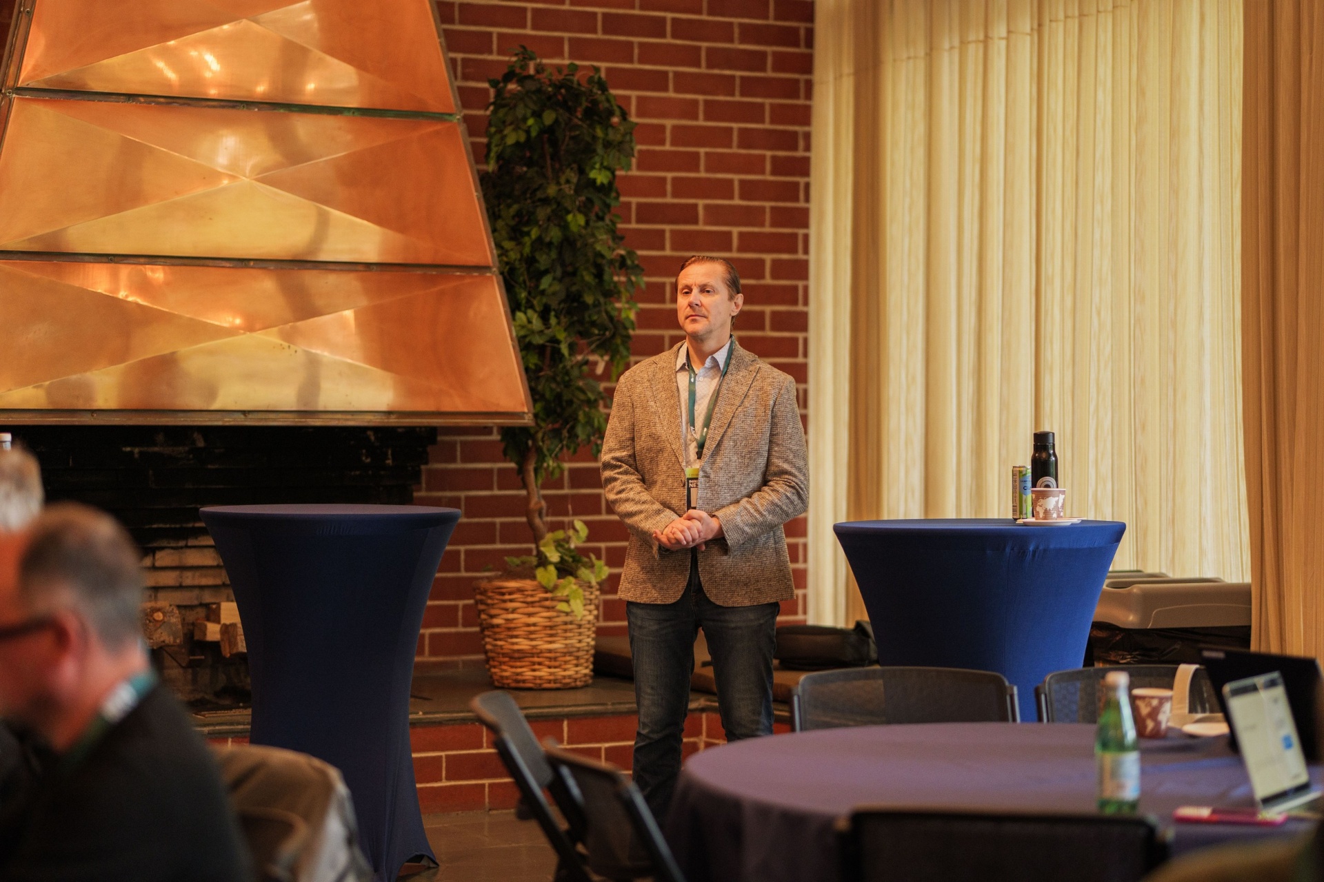 Speaker presenting by the copper fireplace