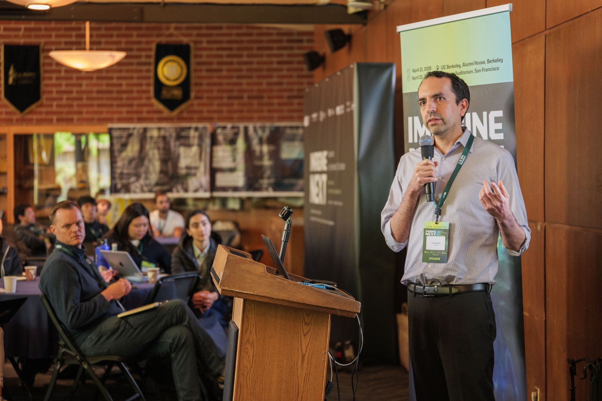 Eric Martinez of Alaris speaking from the podium with engaged audience