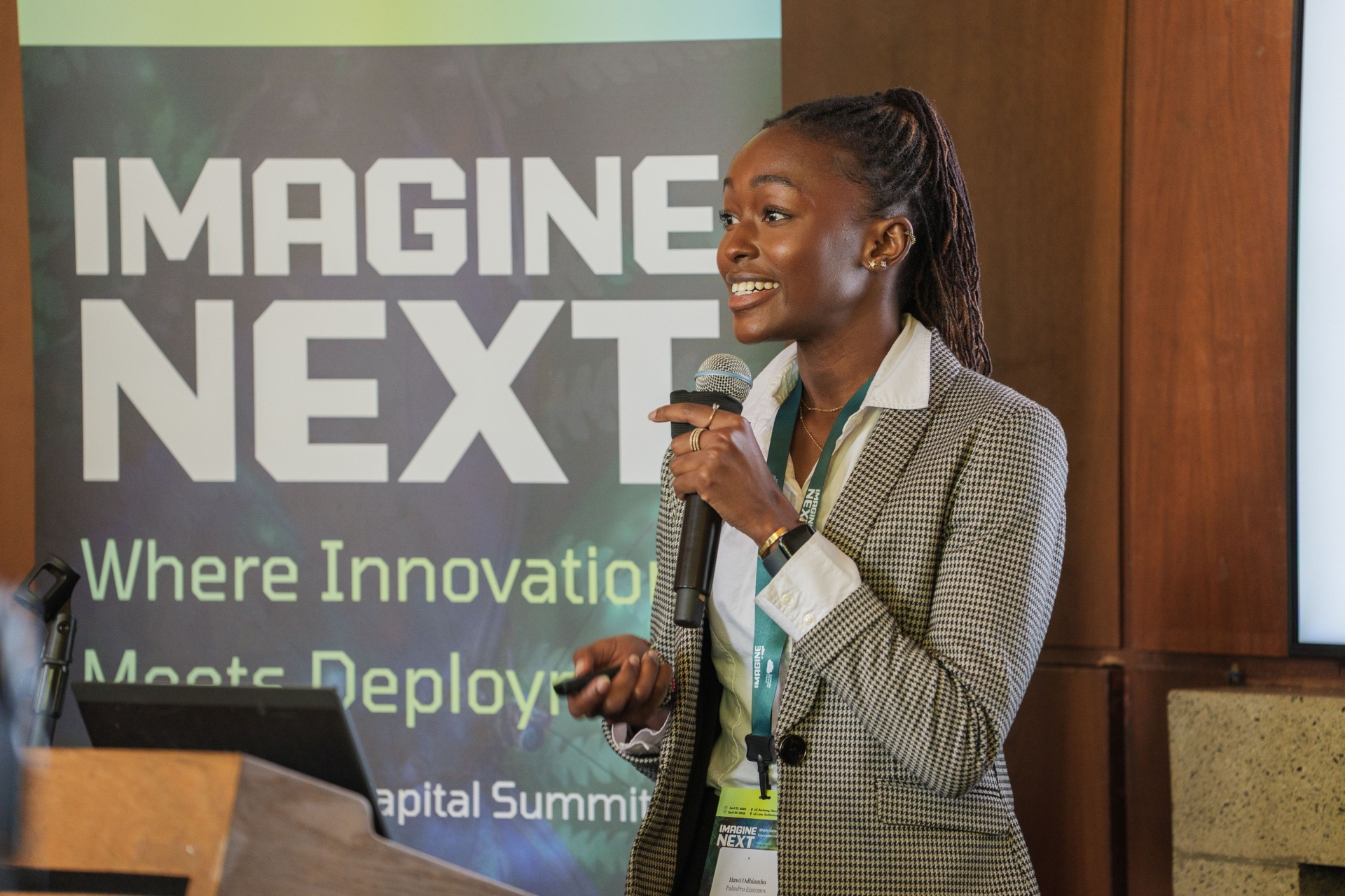 Hawi Odhiambo smiling at the podium beside the Imagine Next banner